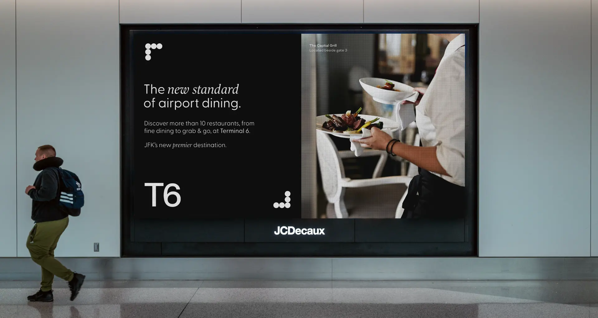 JFK Terminal 6 dining campaign on a large digital billboard in the terminal.