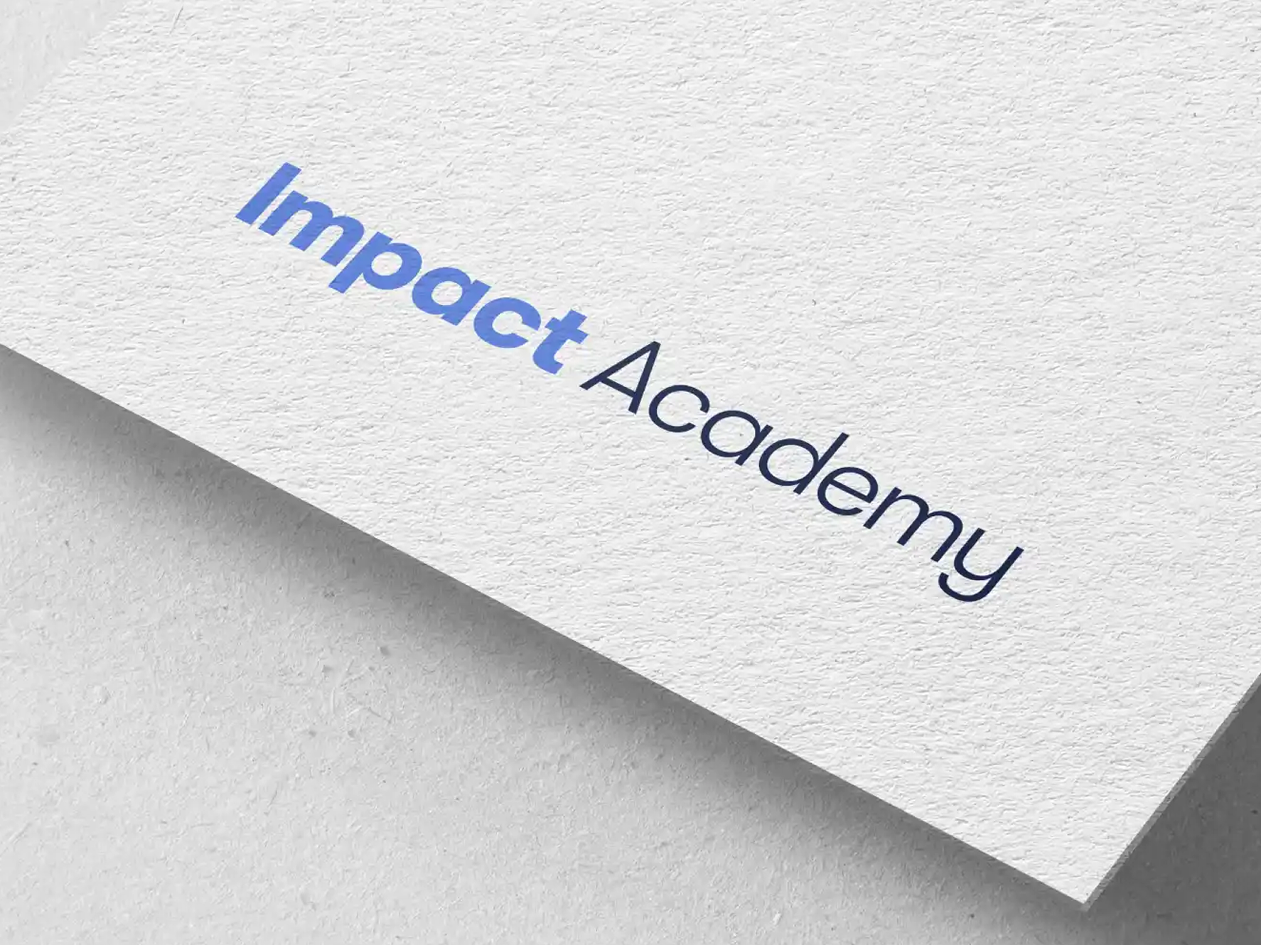 Impact Academy logotype printed in blue and navy on textured paper stock.