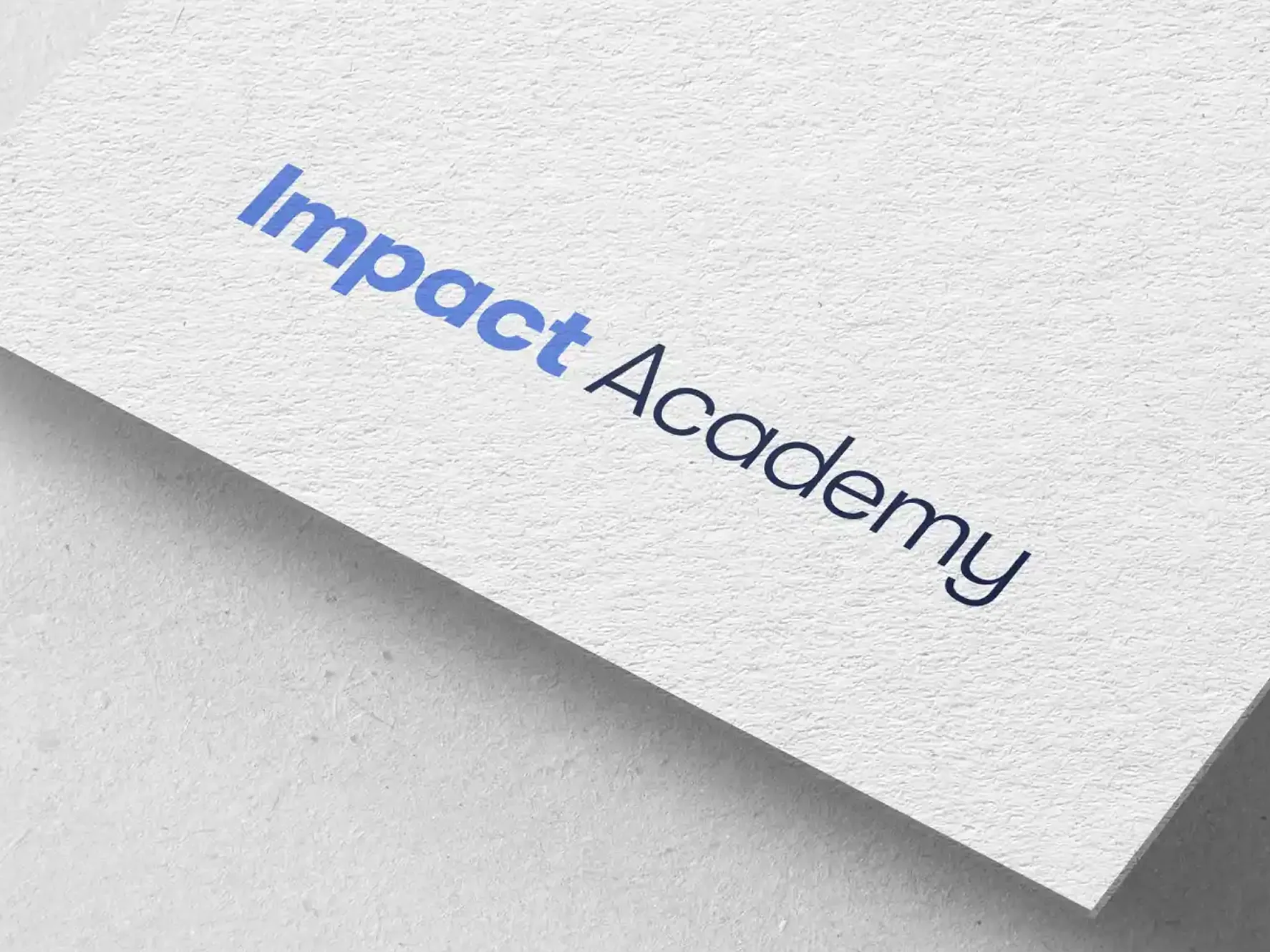 Impact Academy logotype printed in blue and navy on textured paper stock.