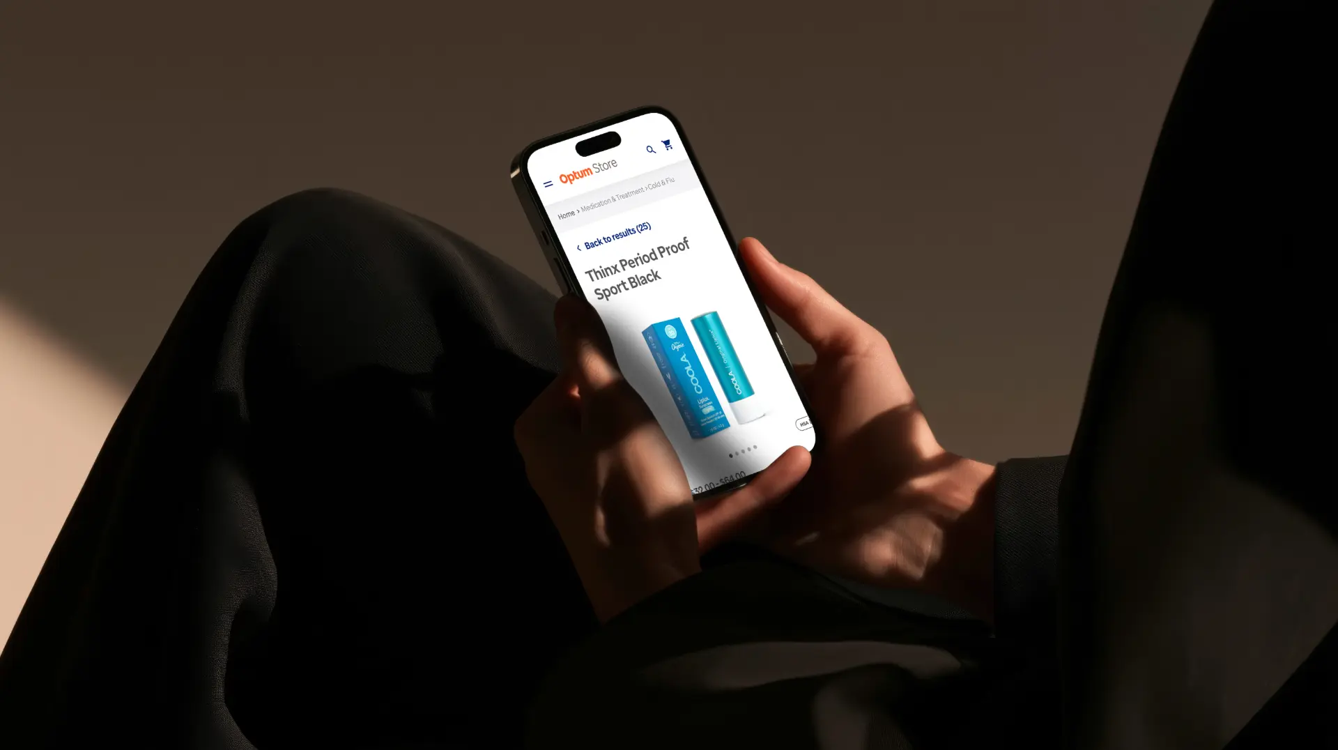 Hand holding a phone showing the Optum Store product page on mobile.