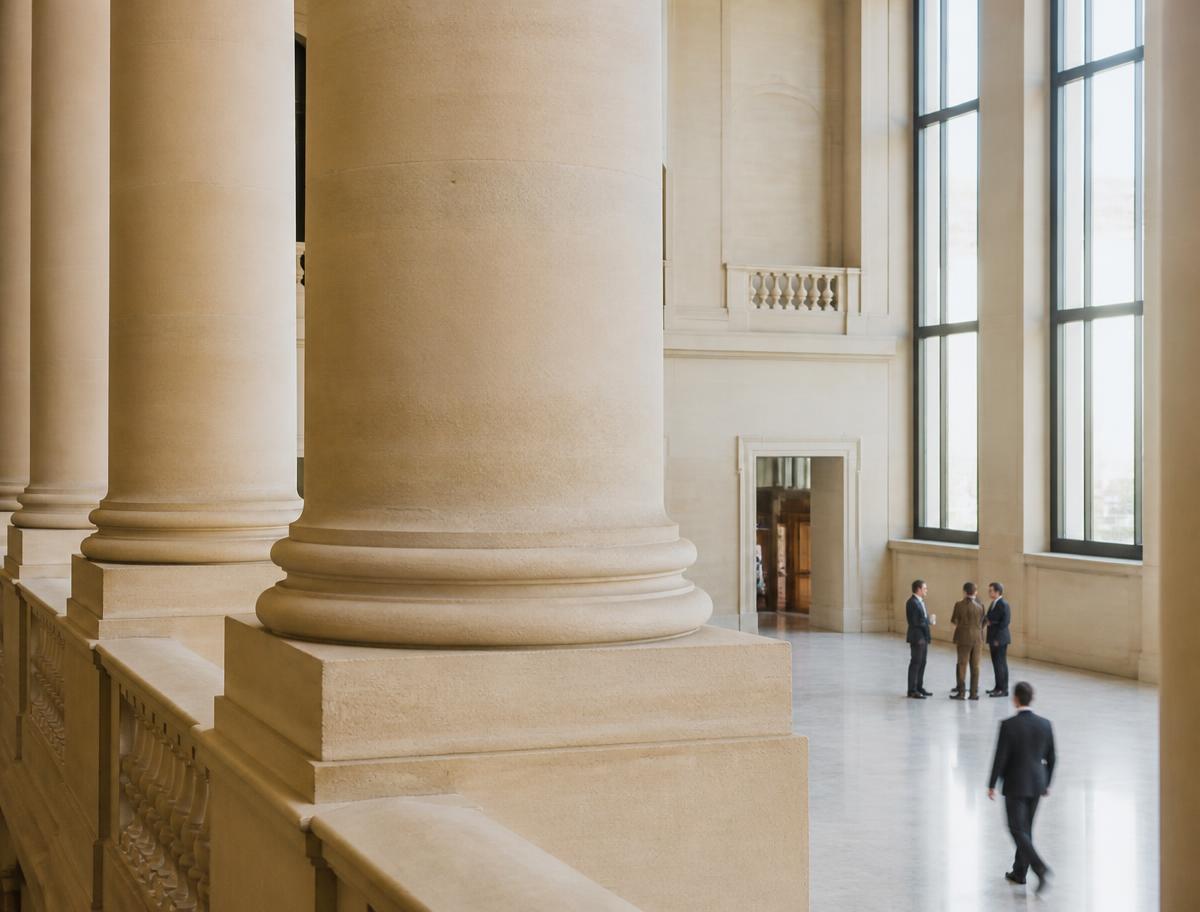 Sunlit civic building atrium with tall stone columns